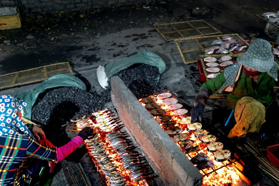 Vendors grilling fresh fish at an outdoor market