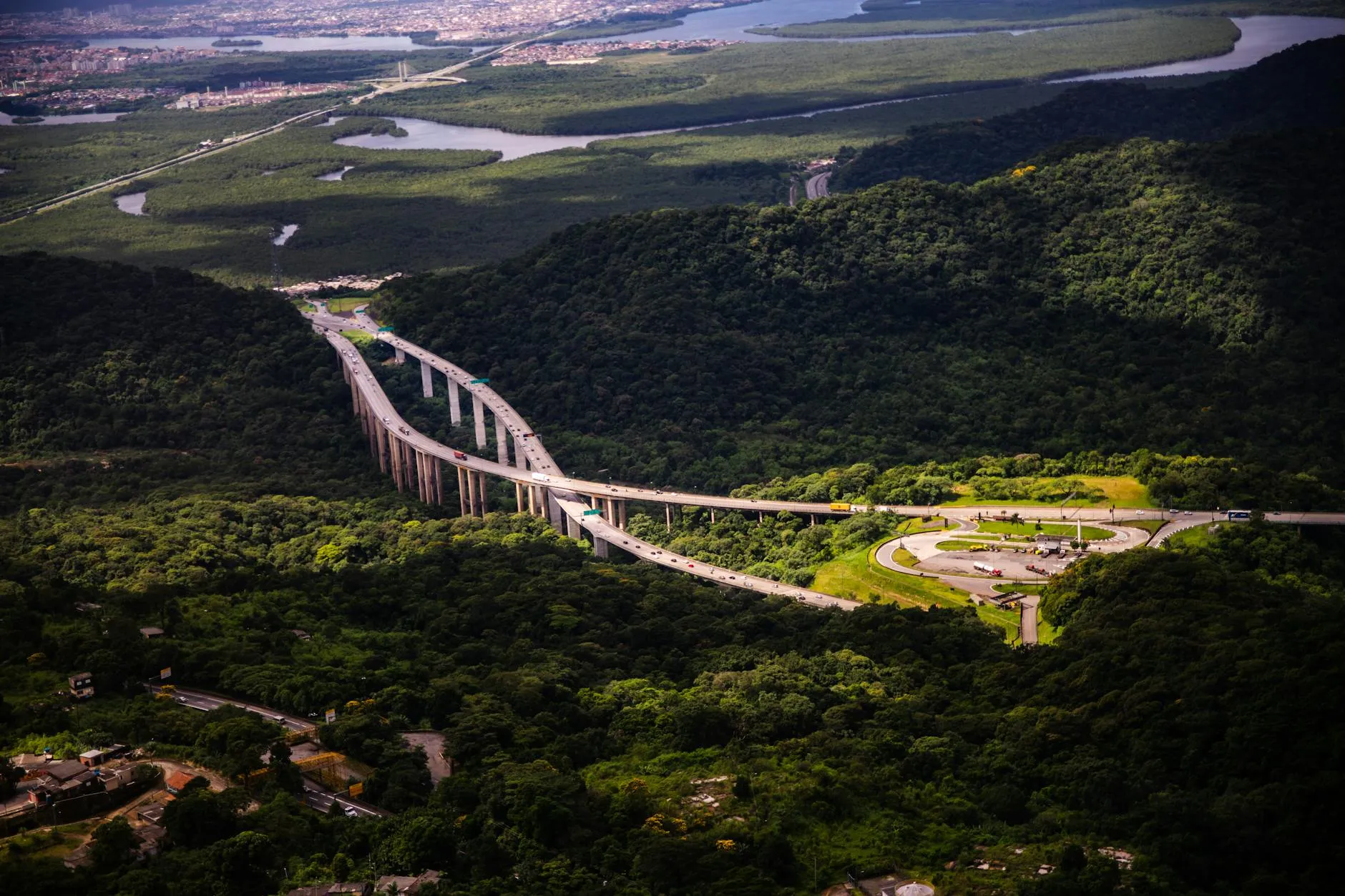 Breathtaking aerial view of a highway cutting through lush greenery in Santos, São Paulo, Brazil.