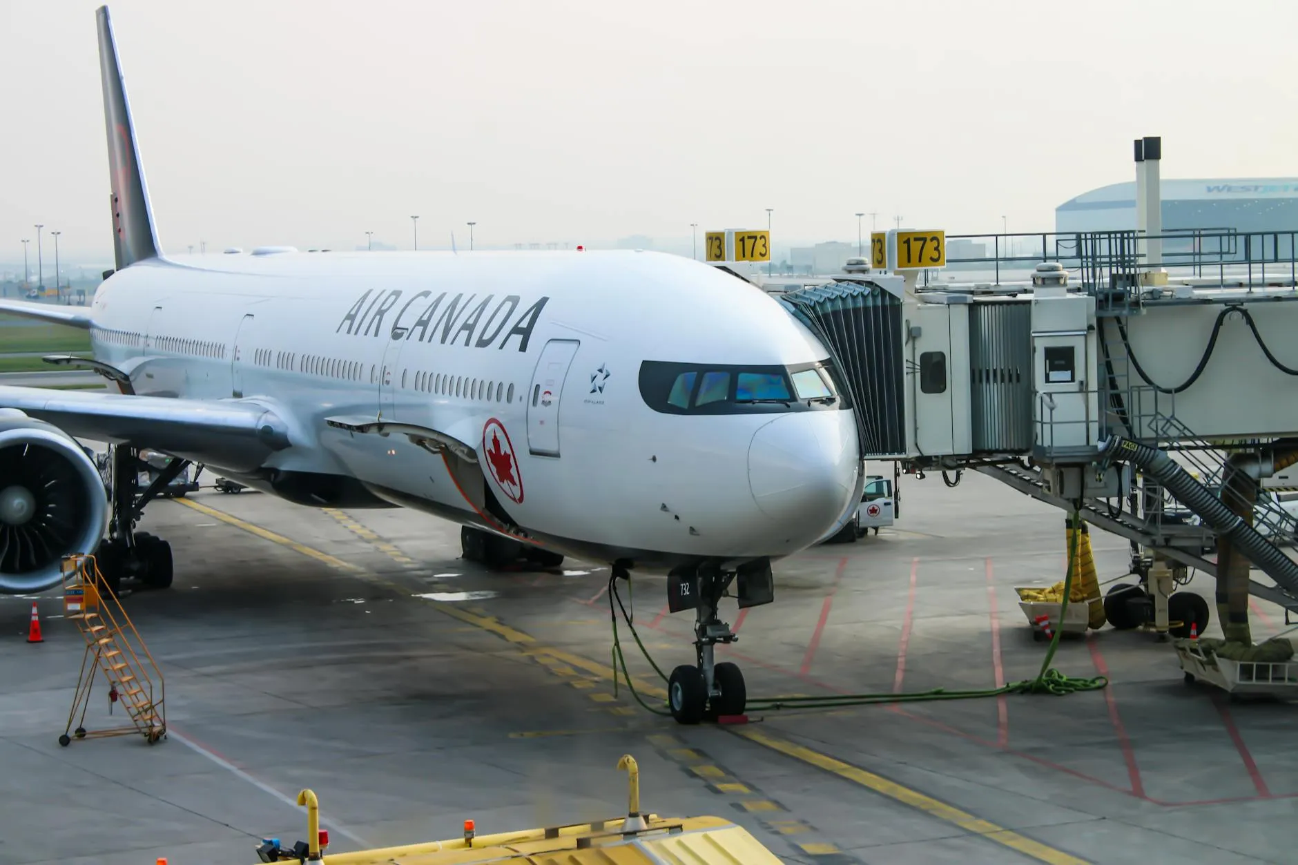 Air Canada aircraft at the gate, ready for passengers. Busy airport scene.