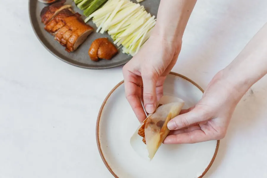 Peking duck being carved tableside with thin pancakes