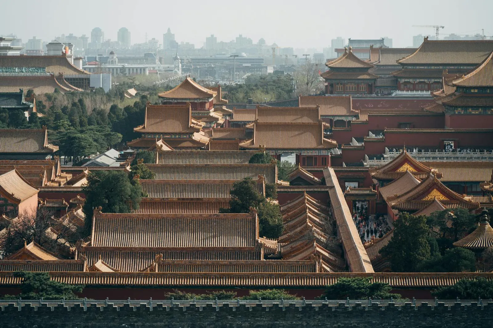 Forbidden City golden rooftops at sunrise with mountains in the distance