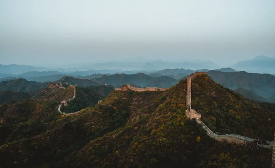 Great Wall of China stretching over forested mountains