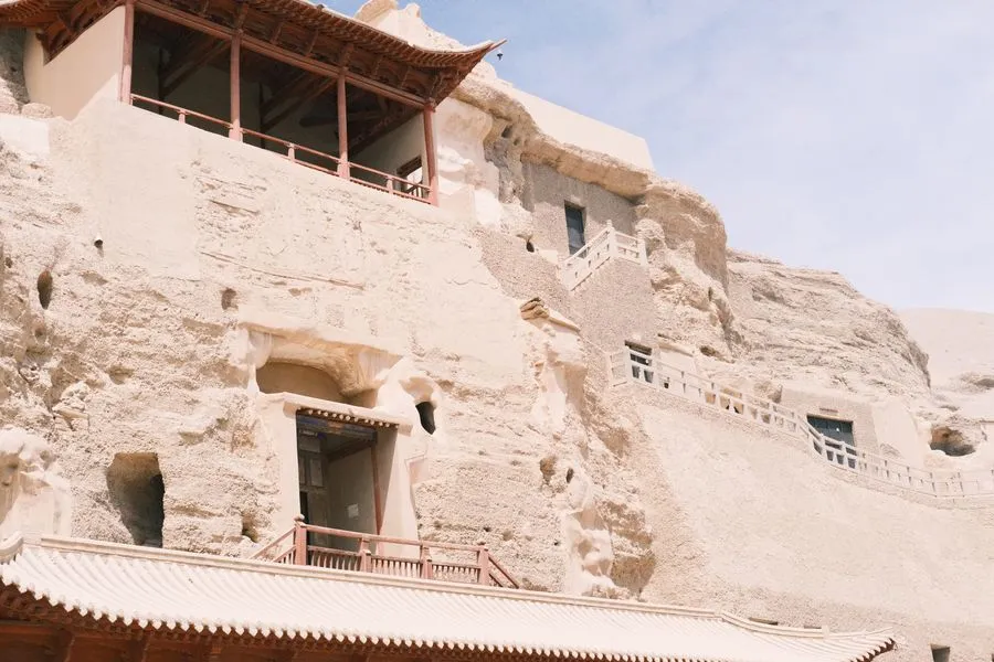 Mogao Caves entrance in the Dunhuang desert with sand dunes behind