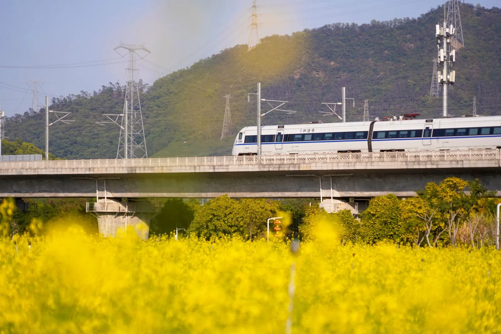 High-speed train passing through Chinese countryside with mountains in background