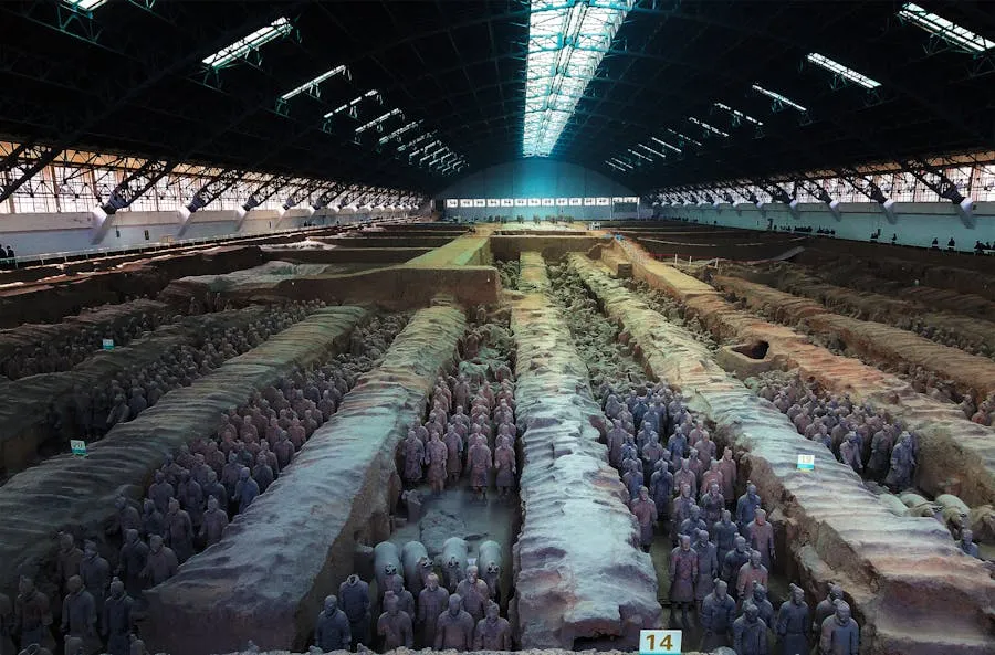 Rows of terracotta warriors standing in excavation pit