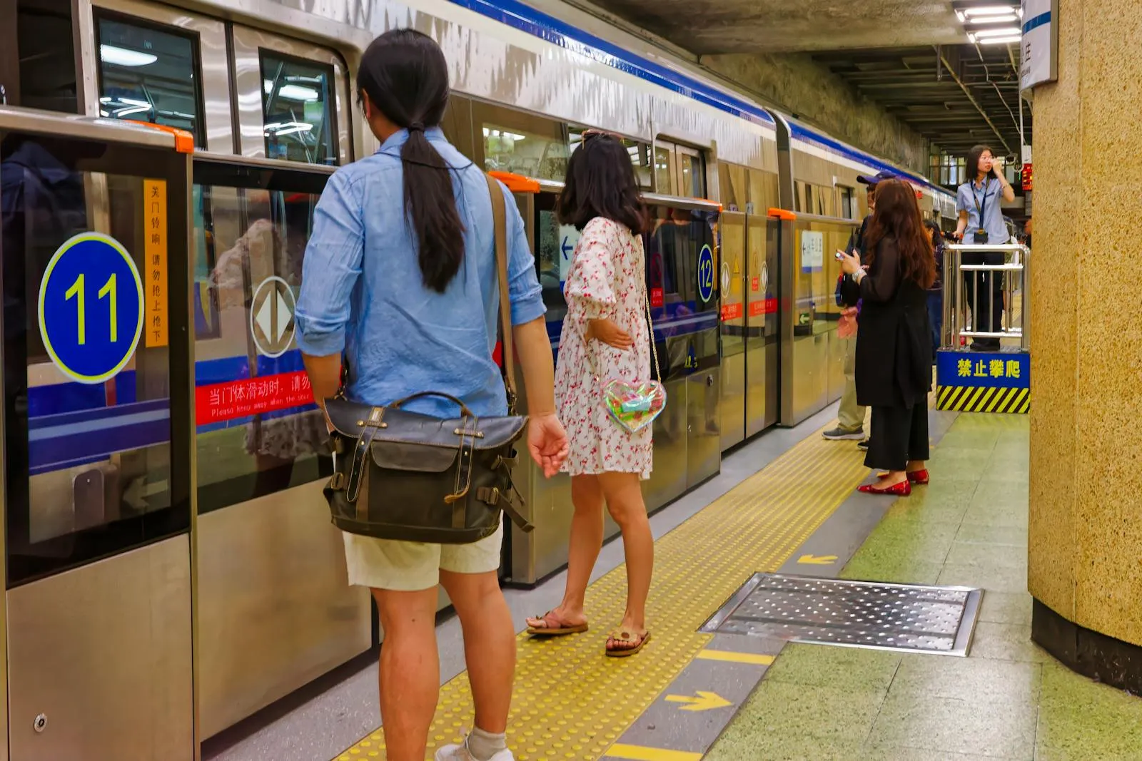 Crowded Beijing subway car during rush hour with passengers checking phones