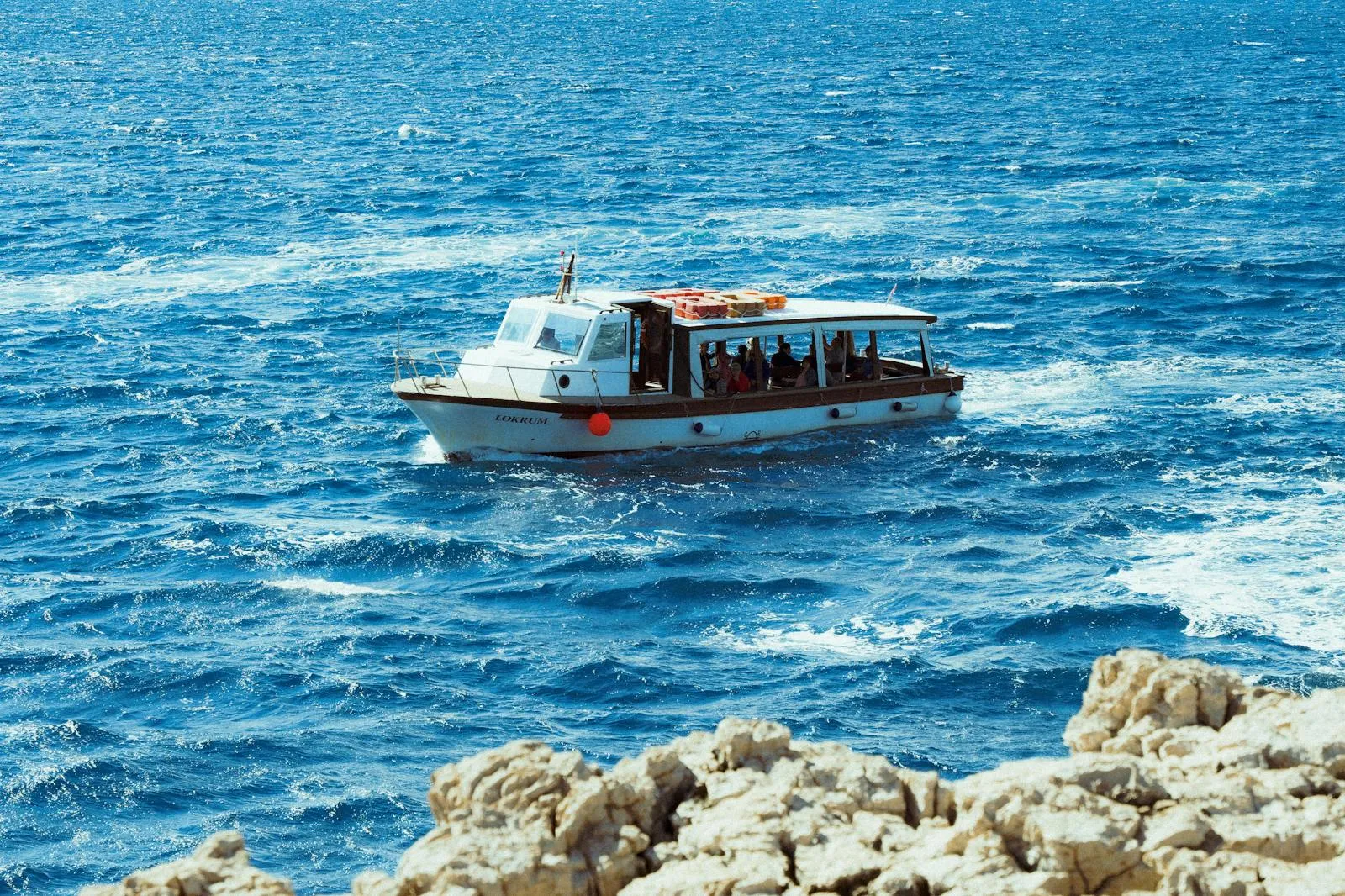 Catamaran ferry crossing blue Adriatic water between Croatian islands