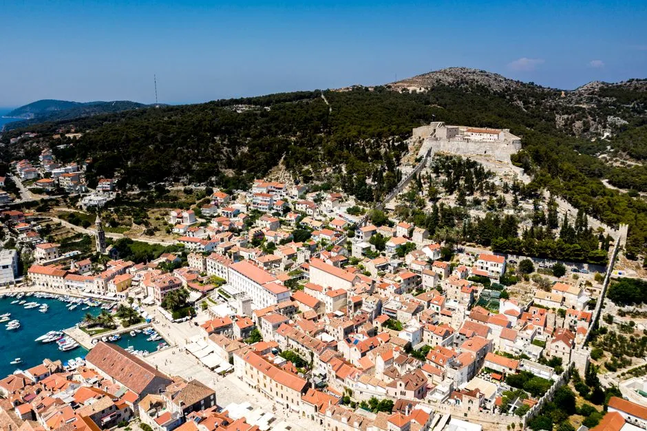 Hvar town harbour with boats and medieval fortress above