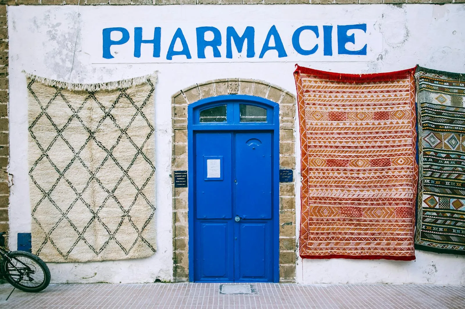 Street signs and a pharmacy green cross in a French town