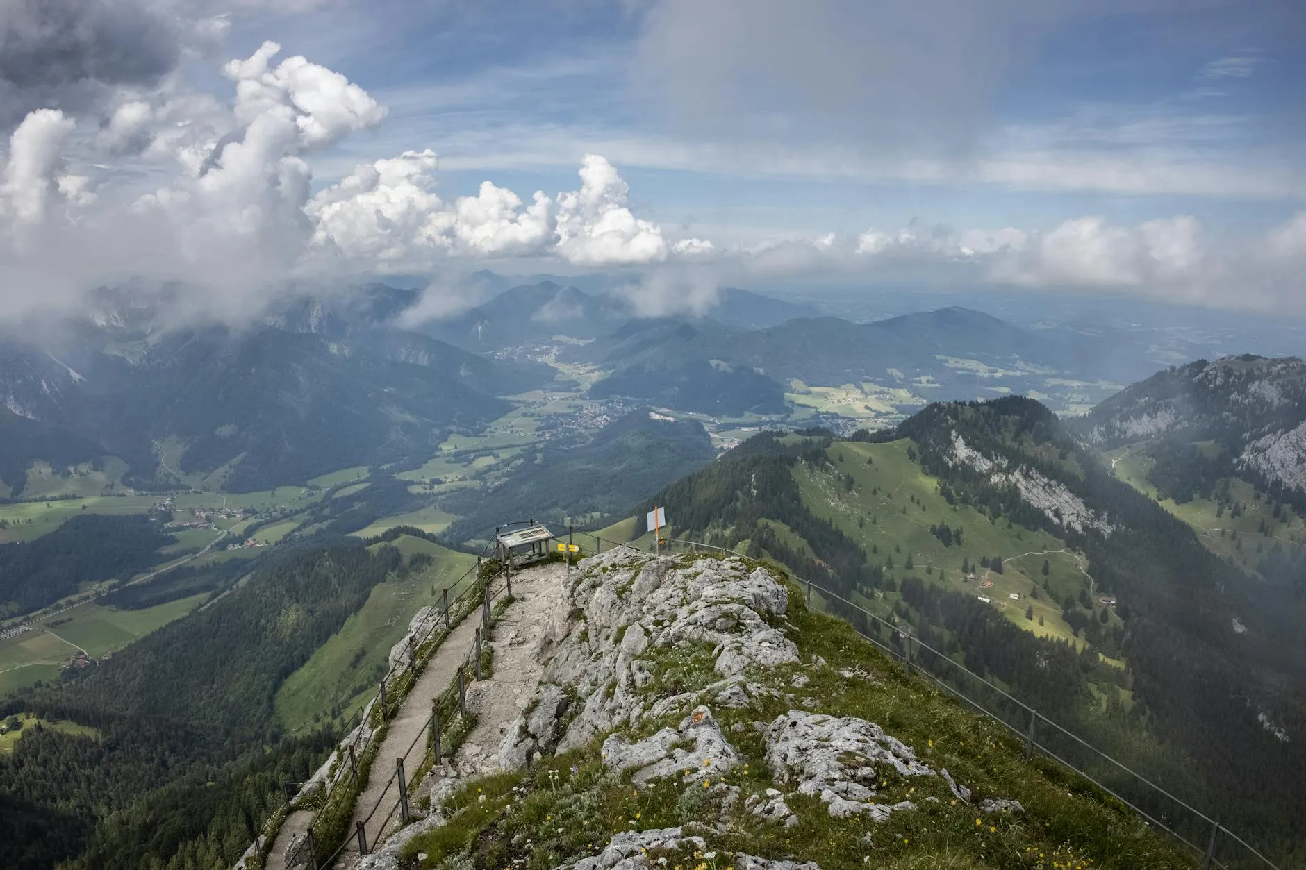 Hikers on an Alpine ridge trail with mountain panorama