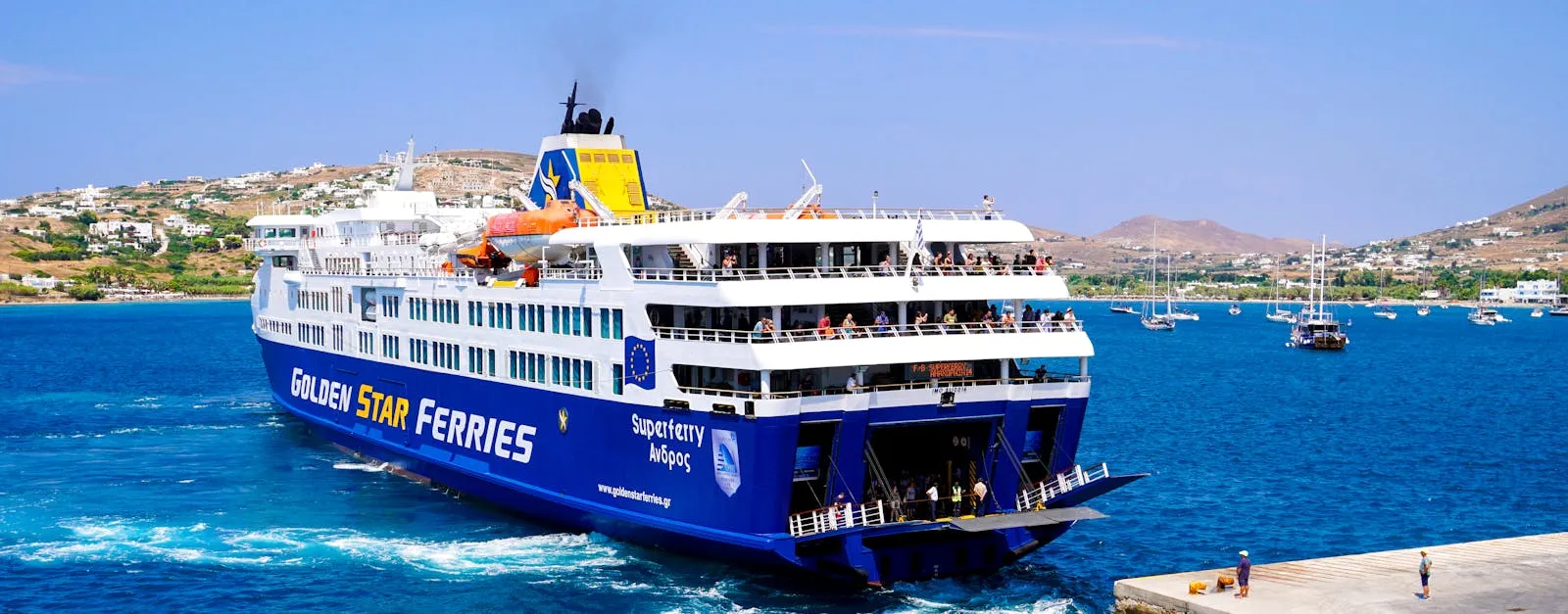 Blue and white ferry approaching a Greek island port