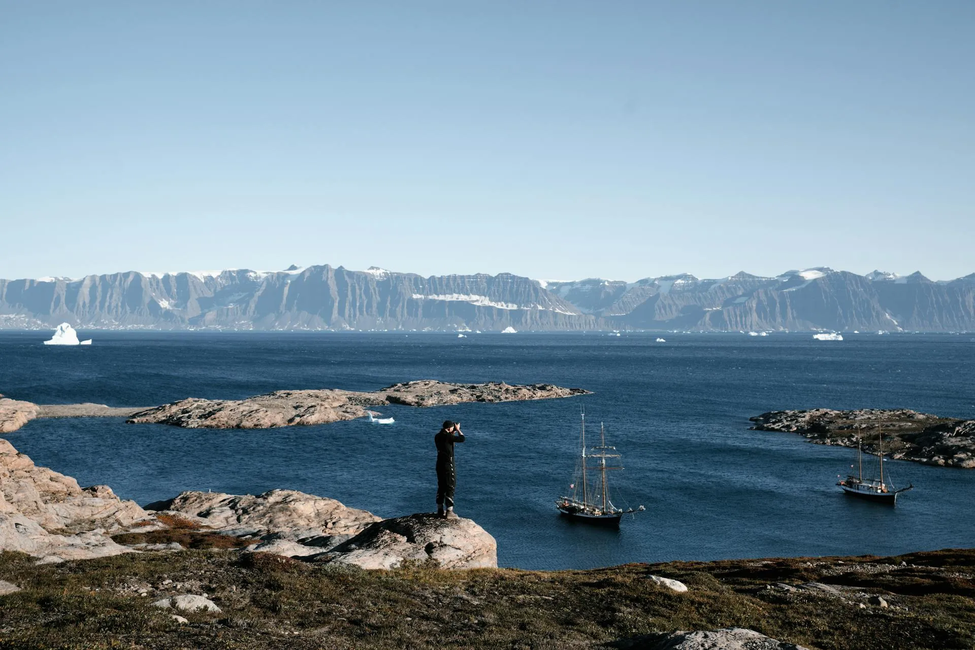 Dramatic Greenland landscape with icebergs and mountains at golden hour