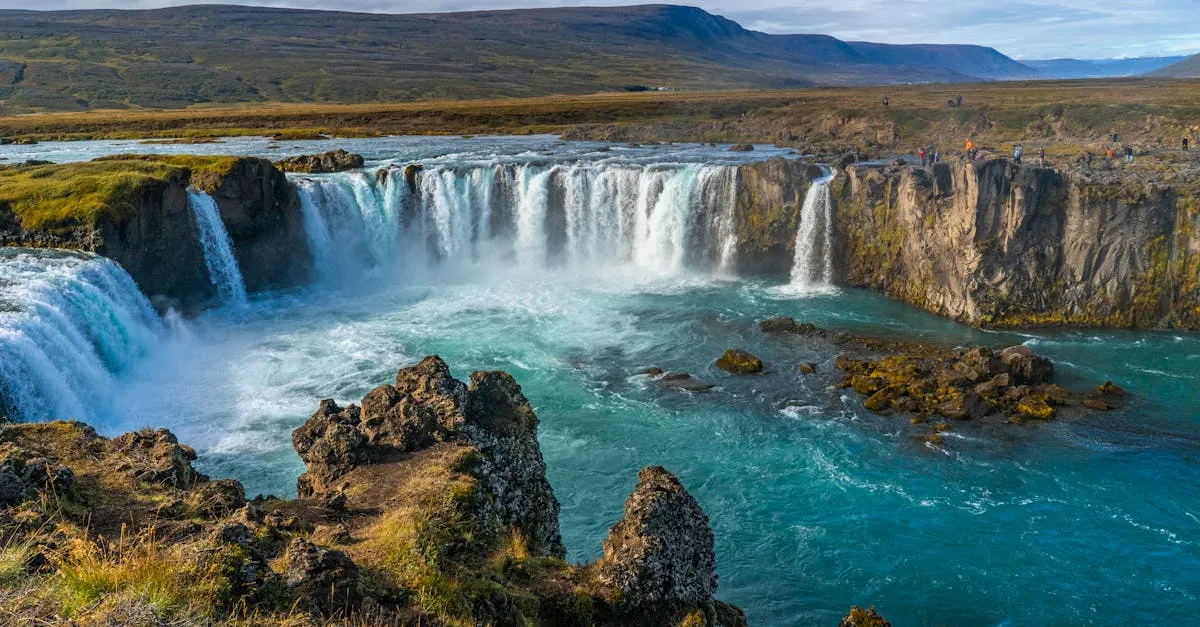 The wide horseshoe curve of Goðafoss waterfall with turquoise water in North Iceland