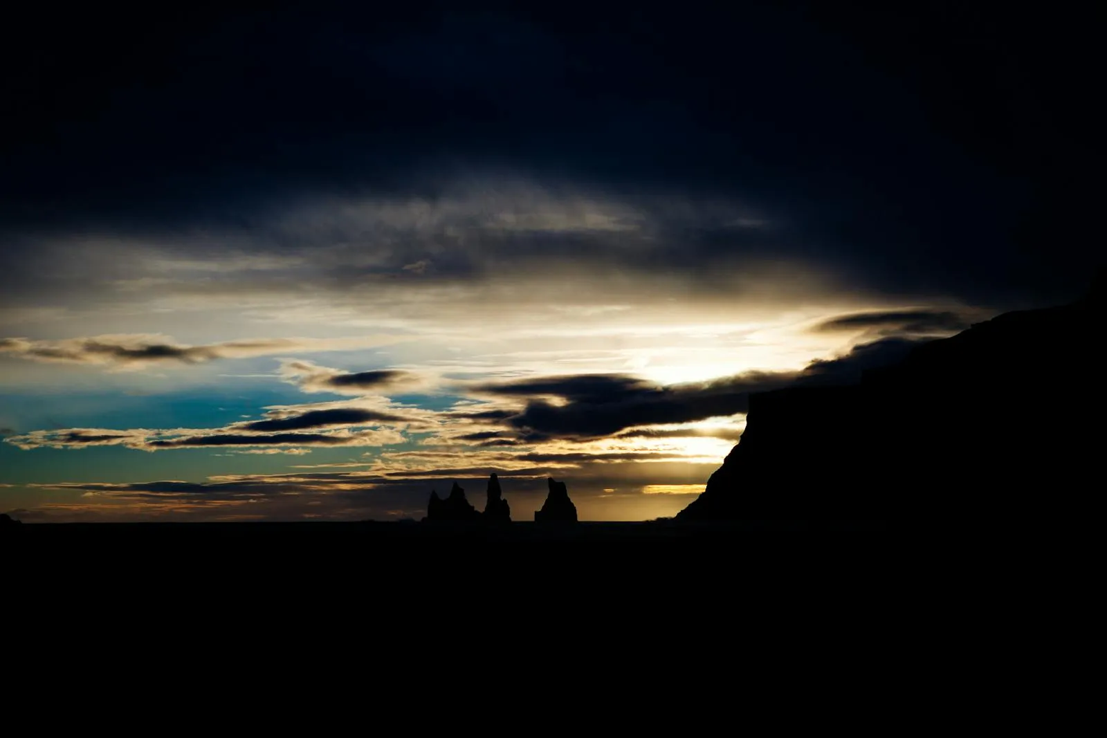 Golden midnight sun casting warm light across a vast Icelandic landscape
