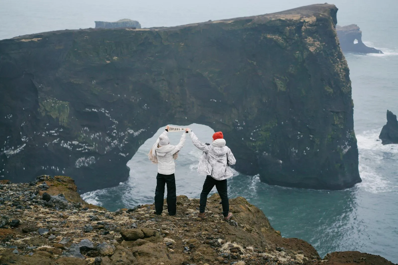 Tourists at a scenic viewpoint in Iceland dressed in weather-appropriate layers