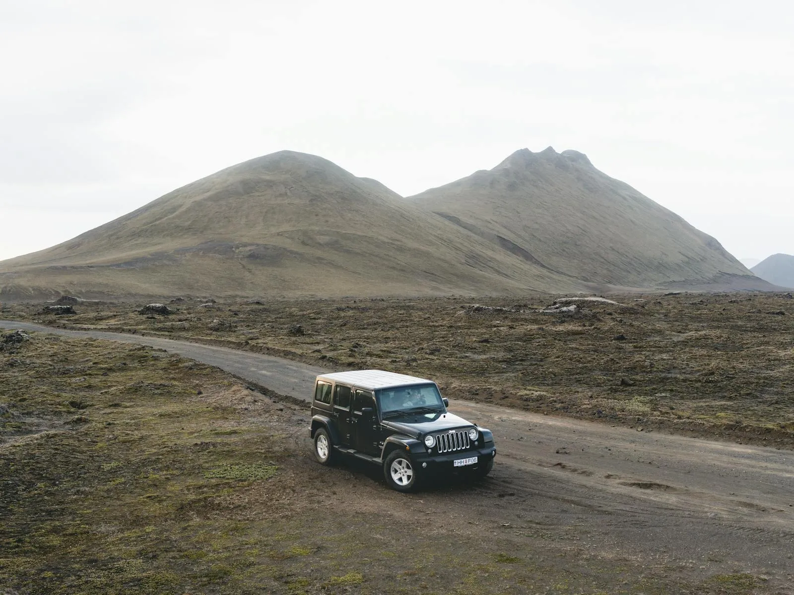 4x4 vehicle on a highland gravel road crossing a river in the Icelandic interior