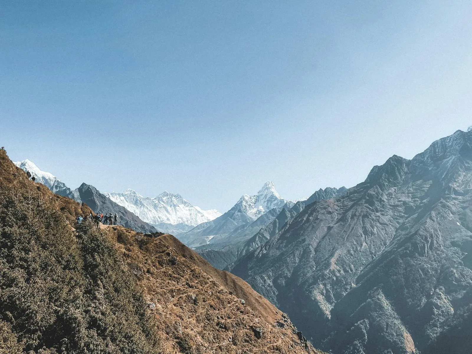Himalayan trekking trail with snow-capped peaks in the distance