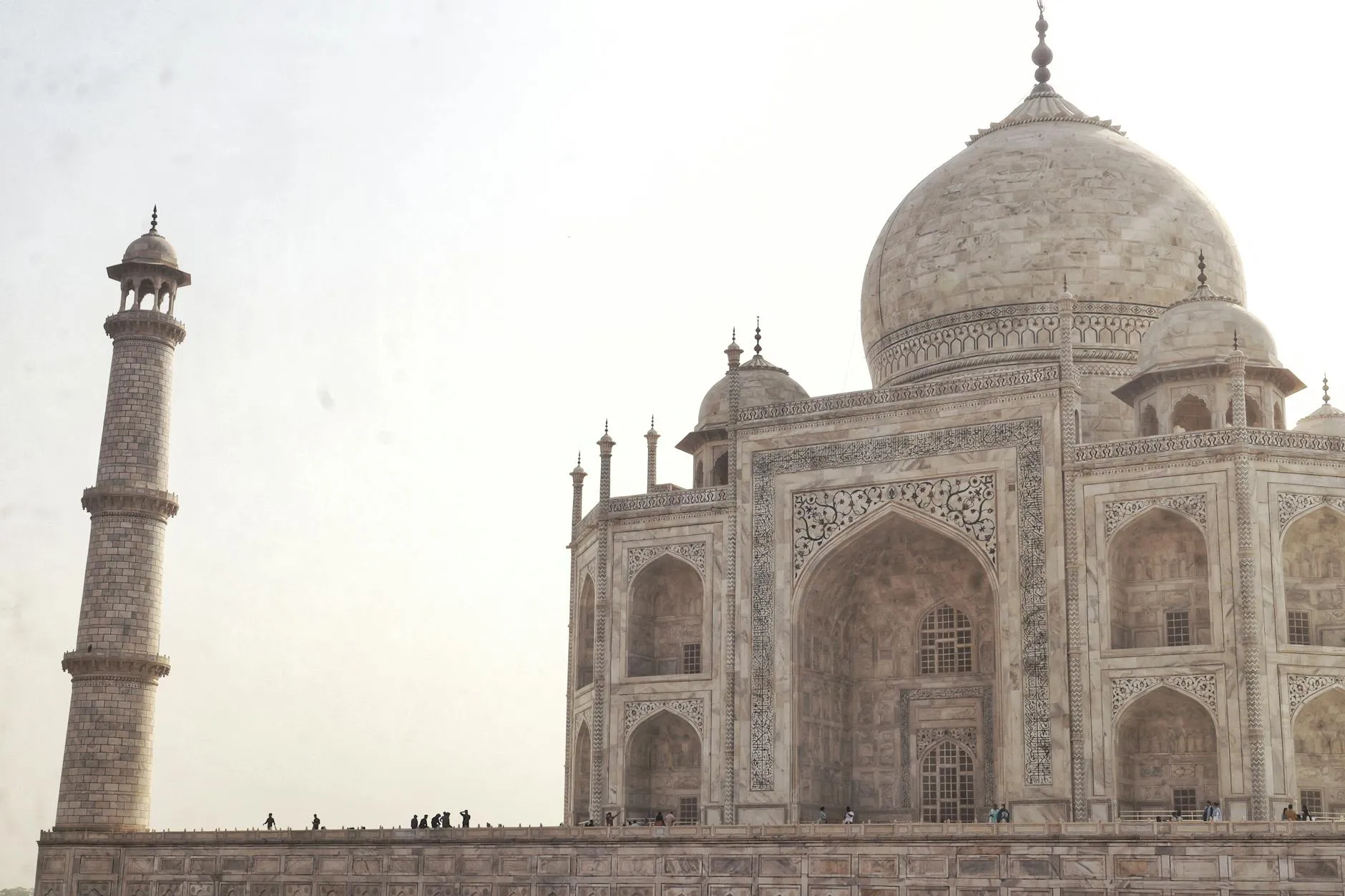 White marble facade of the Taj Mahal reflecting in the pool