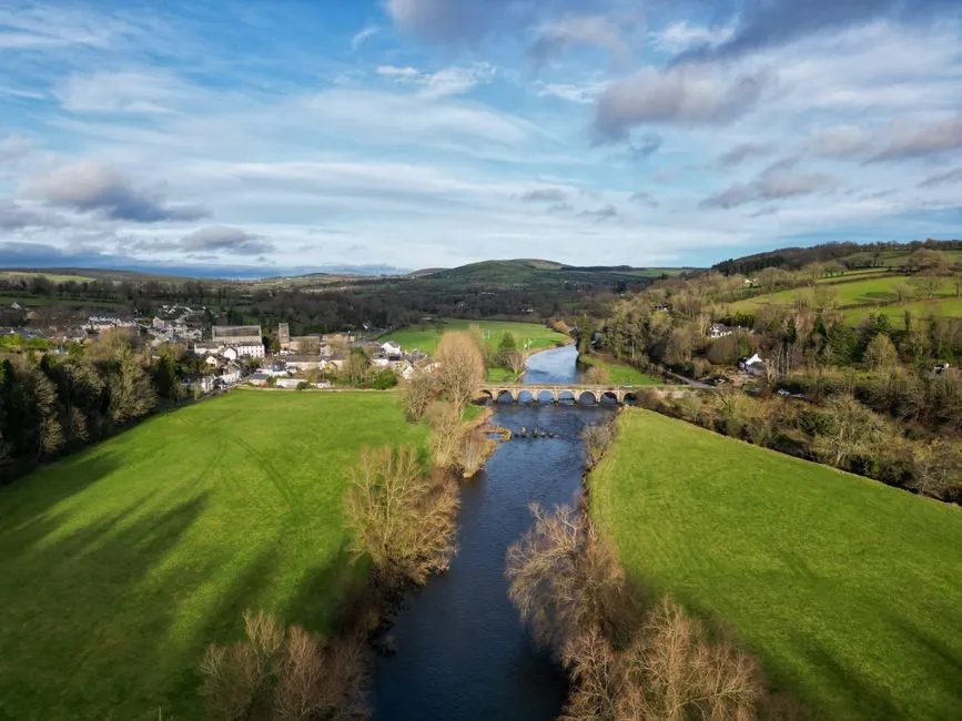 Peaceful river scene in the green Irish midlands with a stone bridge