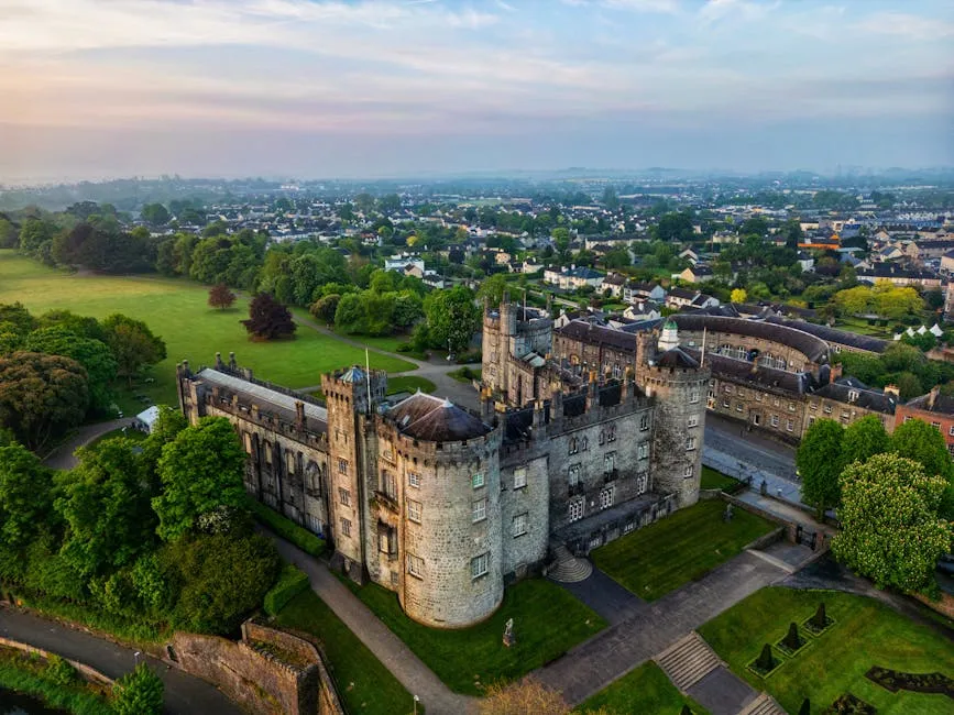 Medieval stone tower in Kilkenny with colourful buildings in the background