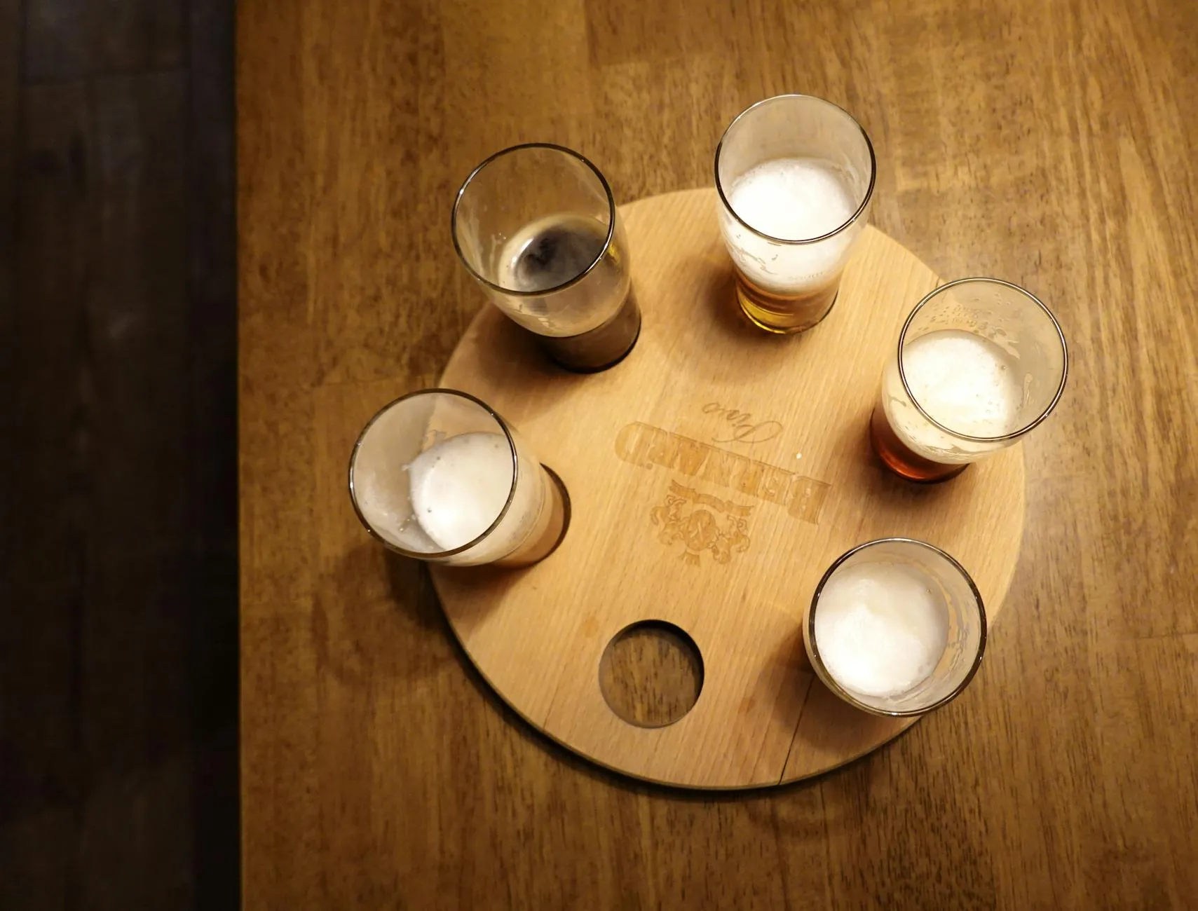 Euro coins and notes spread on a wooden pub table beside a pint of stout