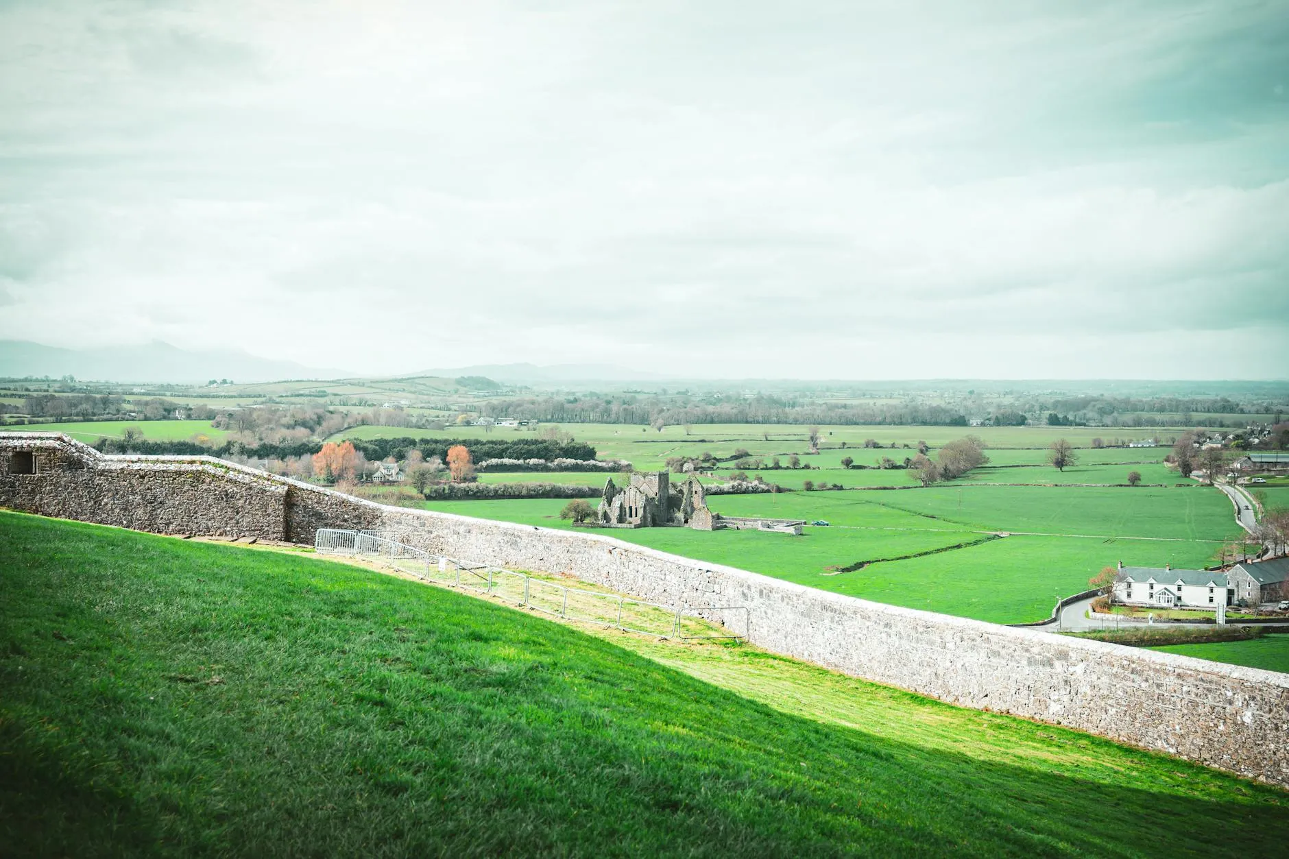 Panoramic view of the Irish countryside with rolling green hills and stone walls