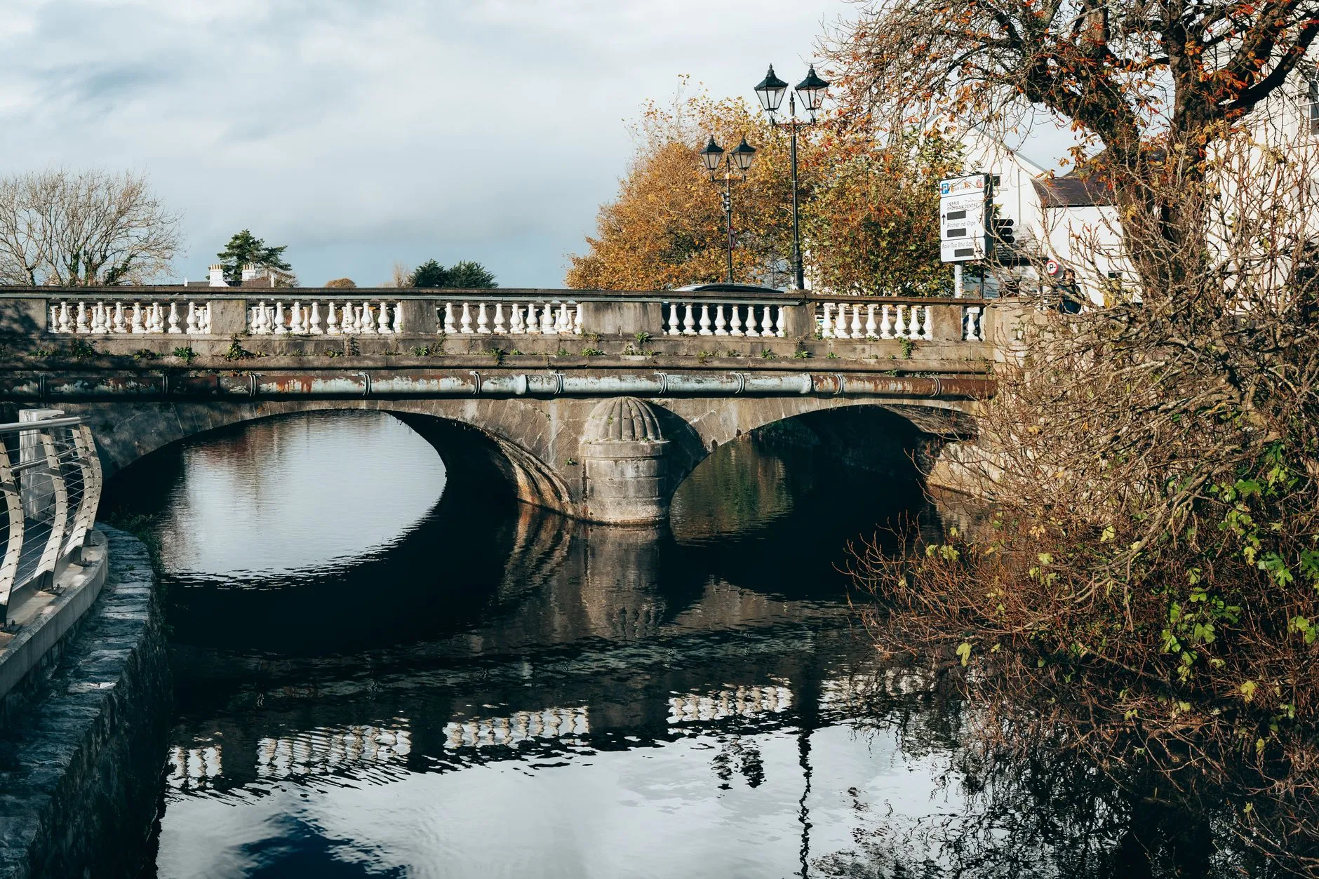 Stone bridge crossing a river in the Irish countryside surrounded by autumn foliage