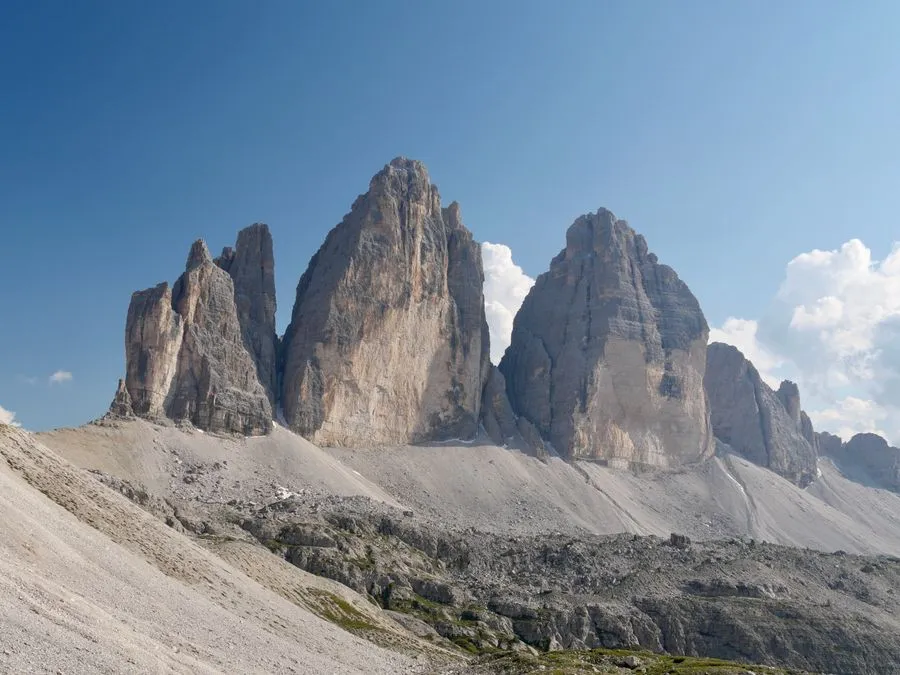 Dramatic pale limestone peaks of the Dolomites rising above alpine meadows