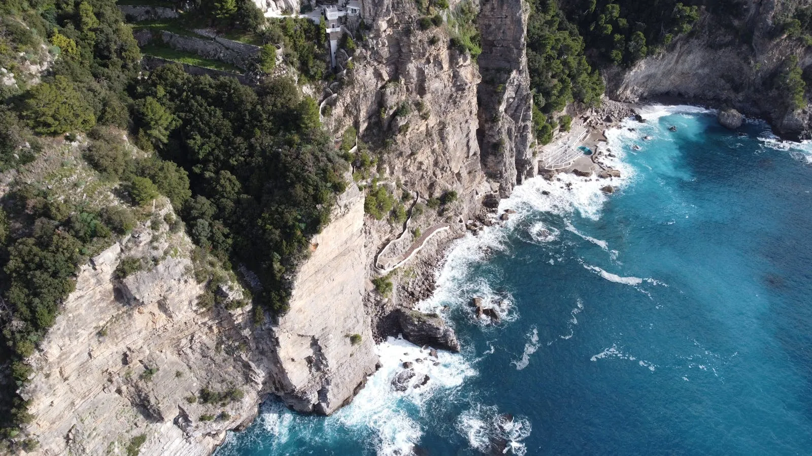 Hikers on the Sentiero degli Dei trail with Amalfi Coast cliffs and sea below