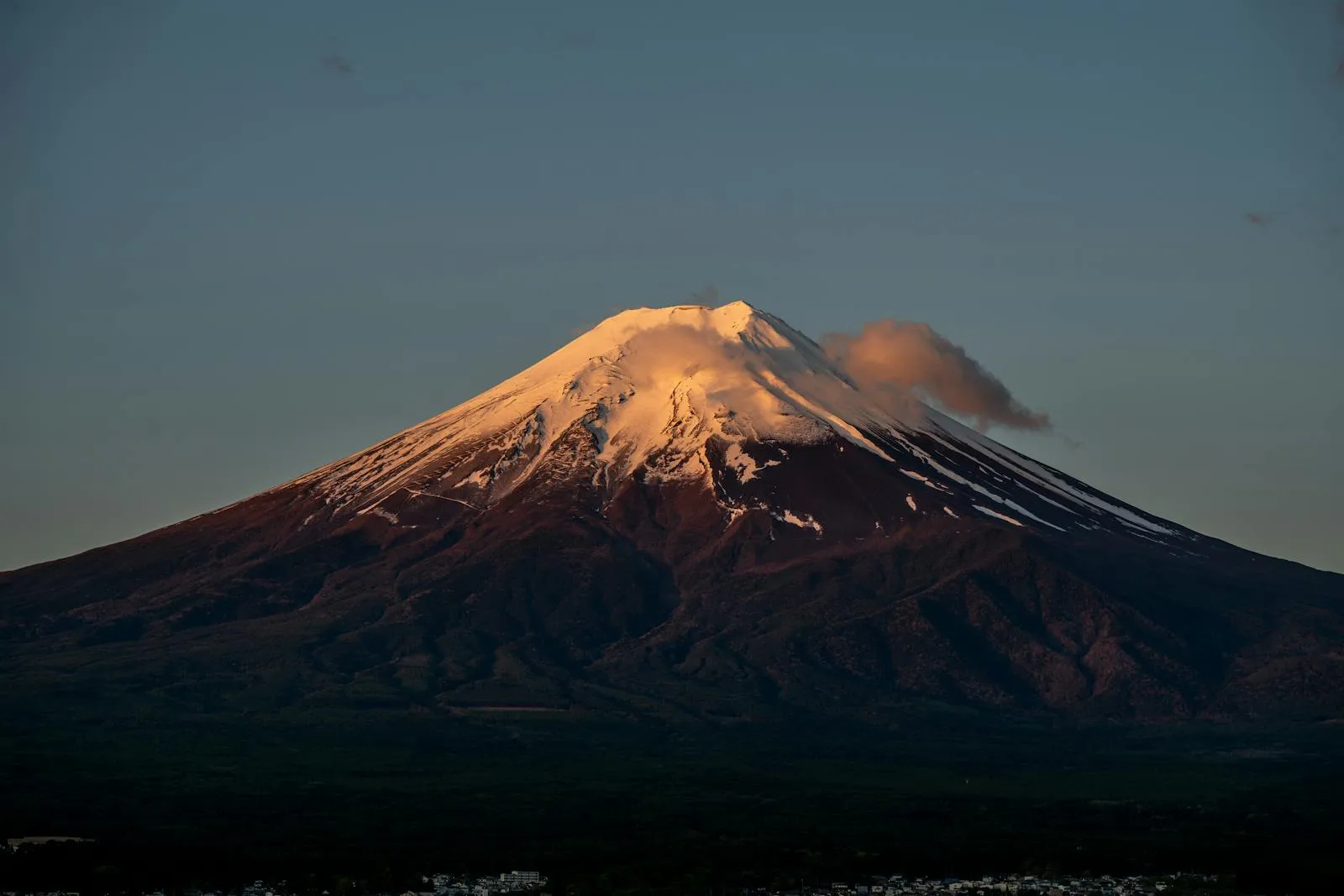 Stunning capture of Mount Fuji with a snowy peak at sunset, showcasing its natural beauty.