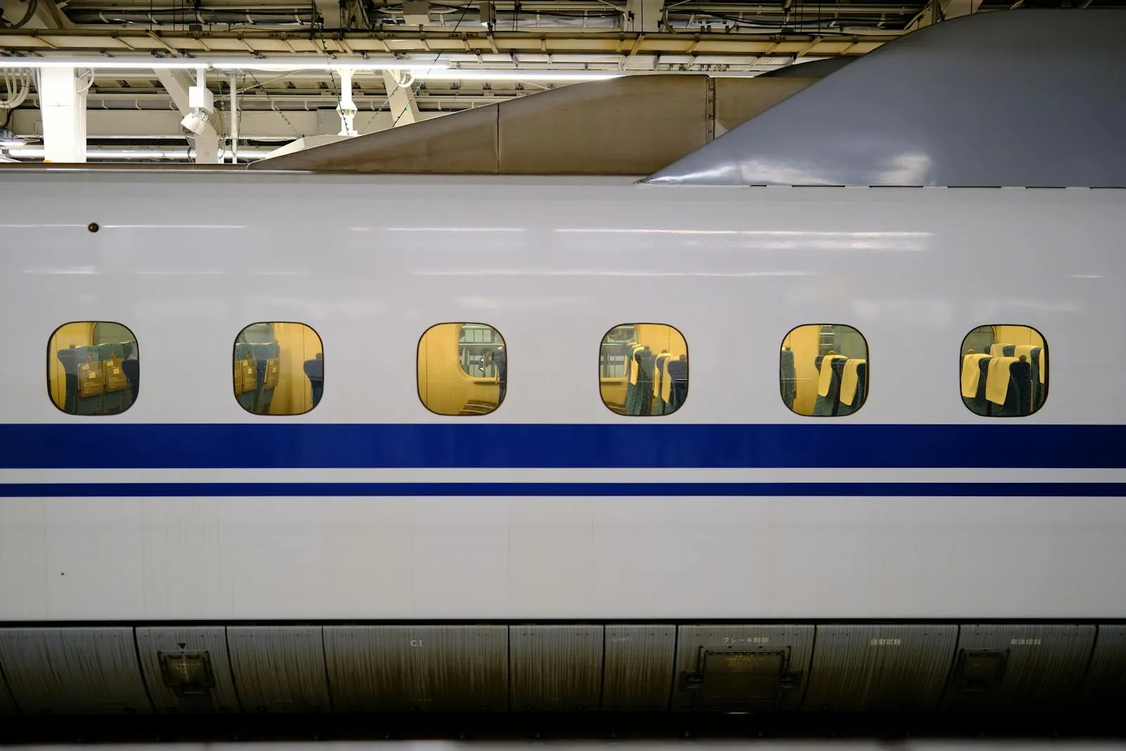 View of the interior of a Shinkansen bullet train through windows at Tokyo Station, Japan.
