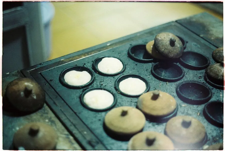 Fresh mofo gasy rice flour cakes cooking on a griddle
