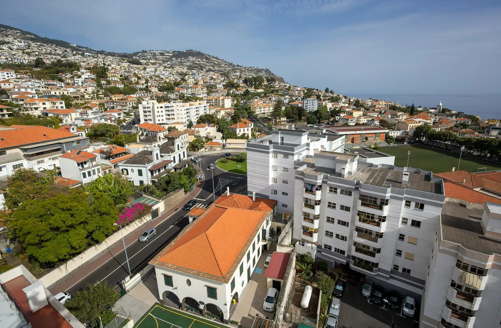 Panoramic view of Funchal bay with colourful houses cascading down green hillsides to the Atlantic Ocean