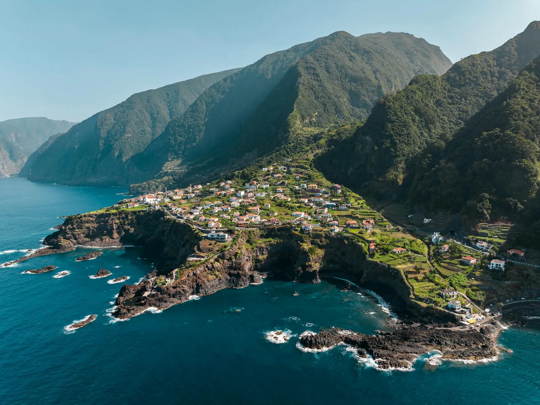Aerial view of Madeira island showing green mountains meeting the Atlantic