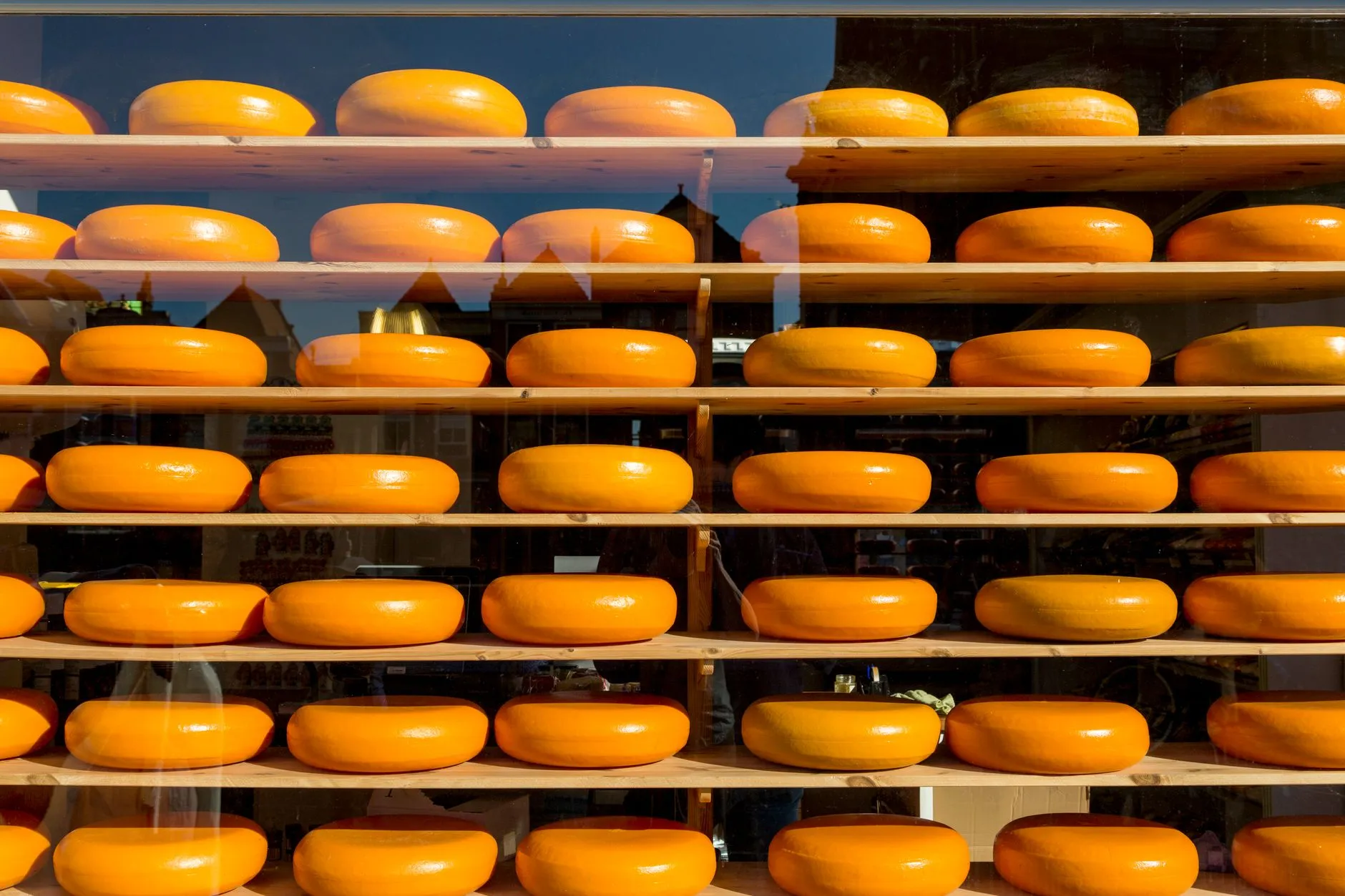 Dutch cheese wheels stacked at a traditional market stall