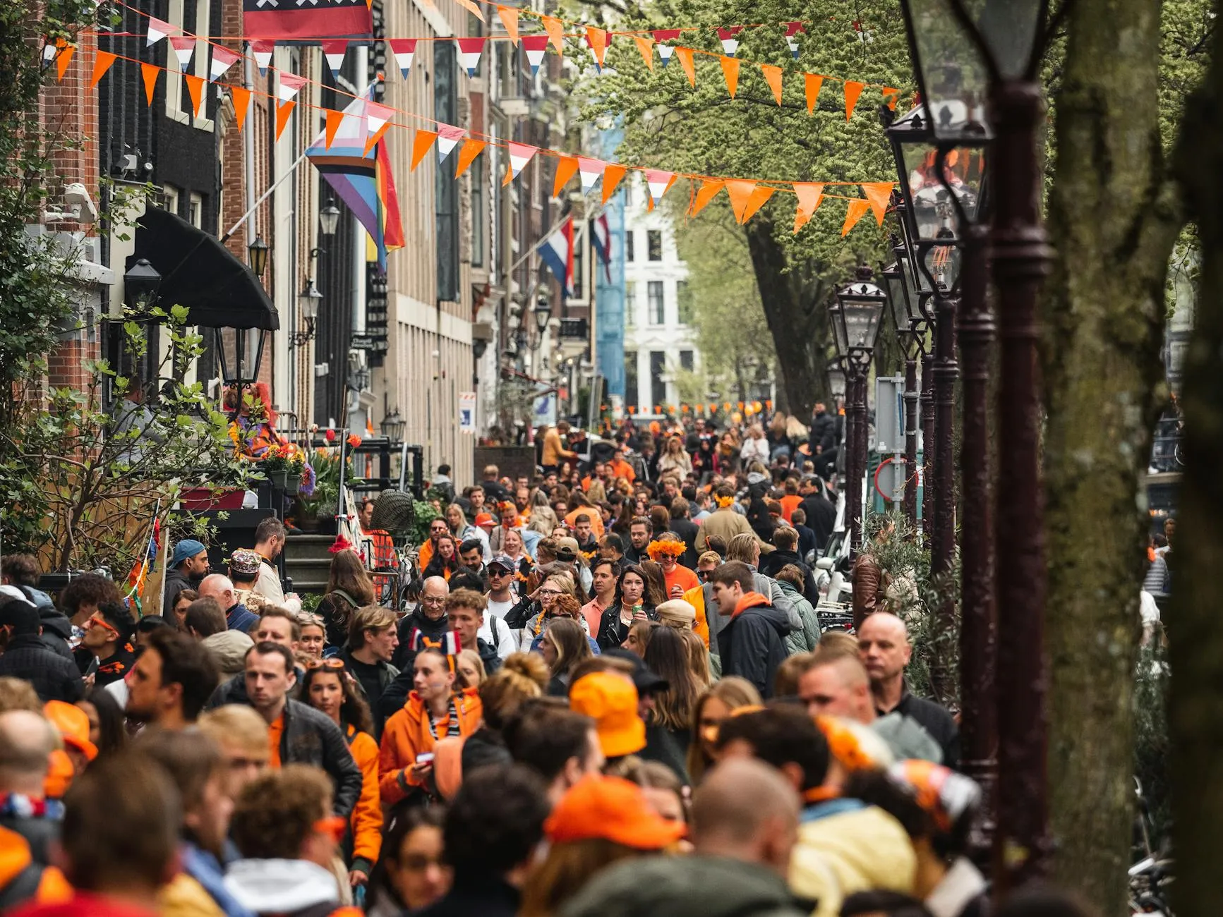 Orange-clad crowds celebrating King's Day along Amsterdam canals