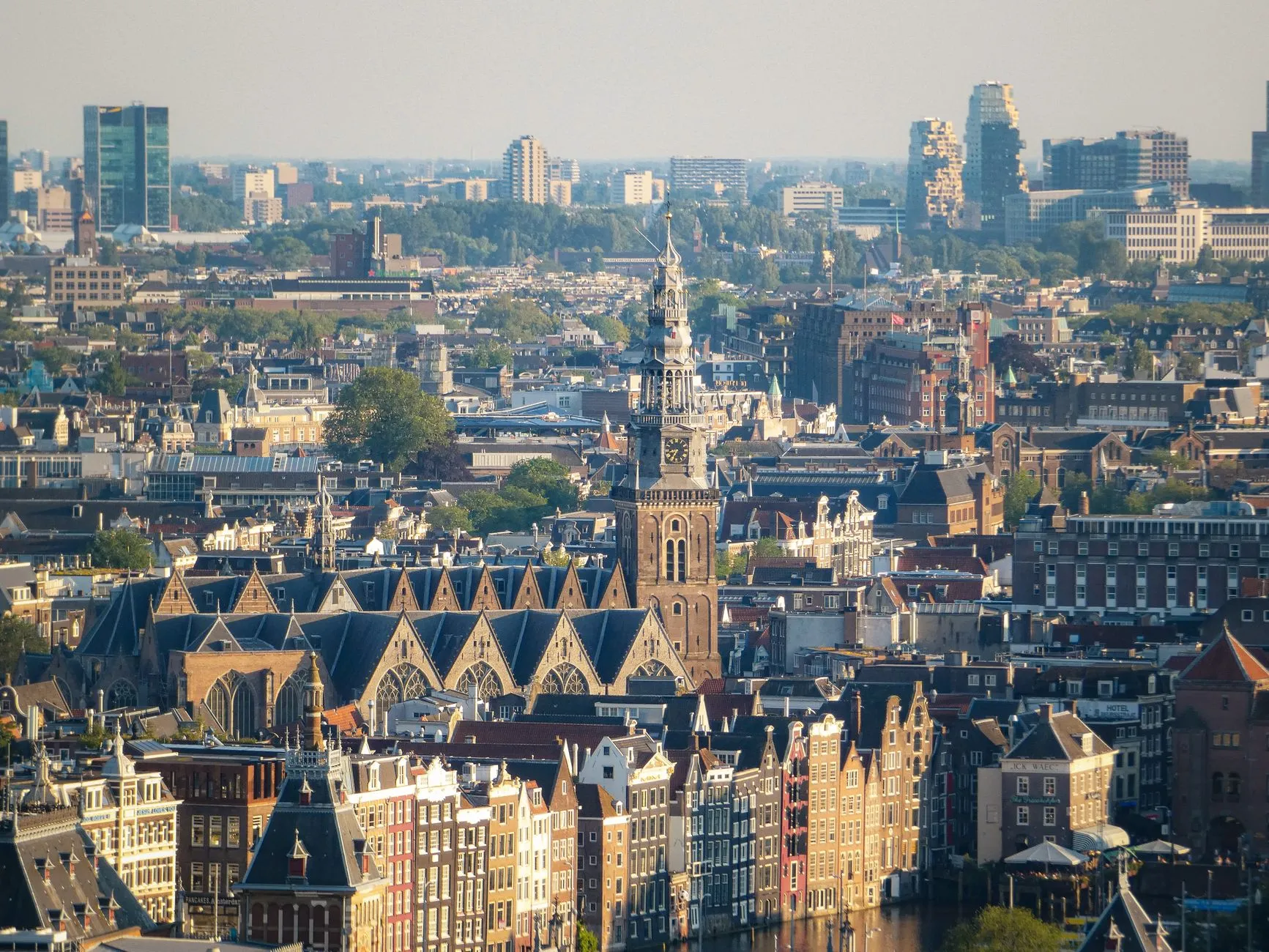 Panoramic view of Amsterdam canal houses with bicycles and houseboats