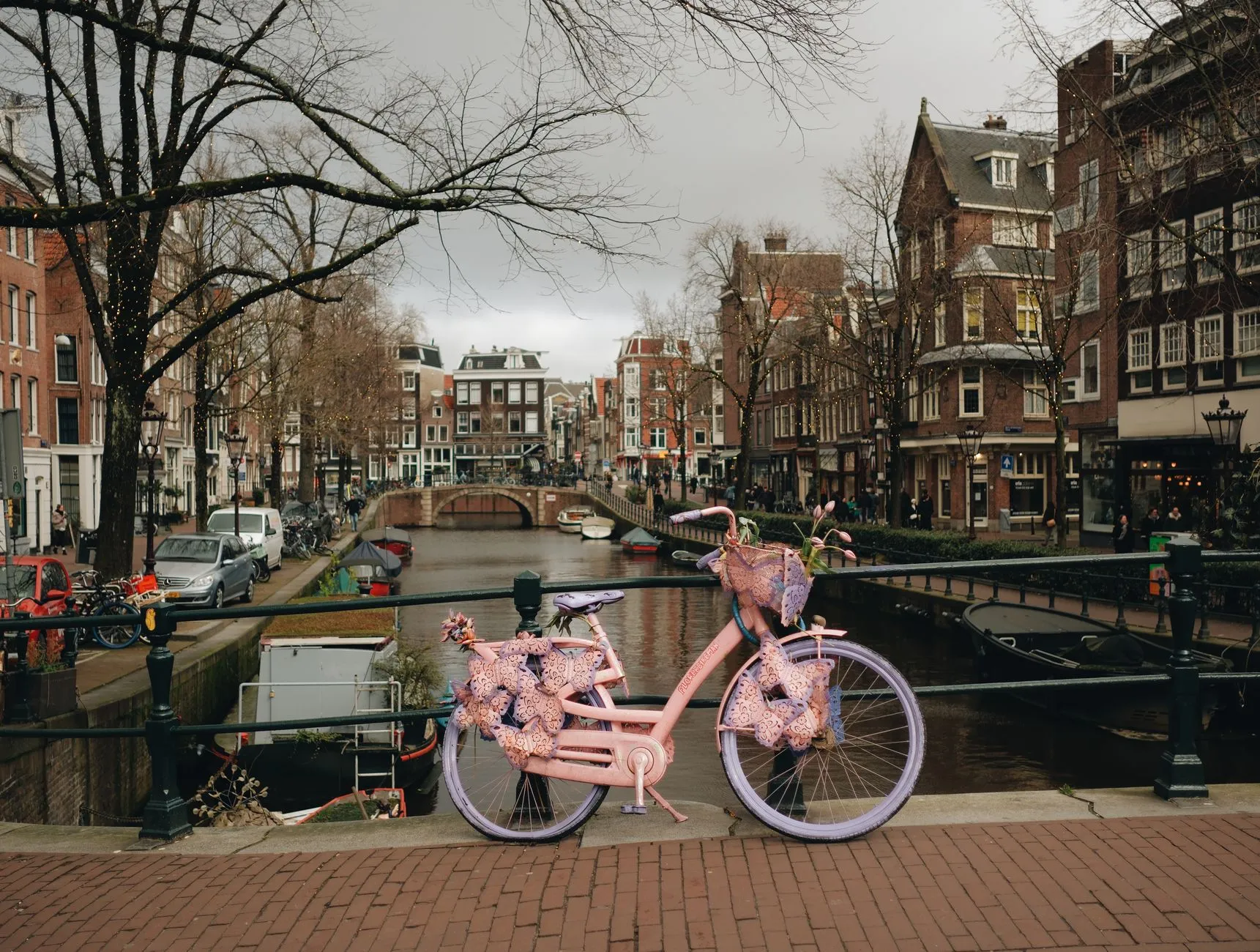 Row of colourful bicycles parked along an Amsterdam canal railing