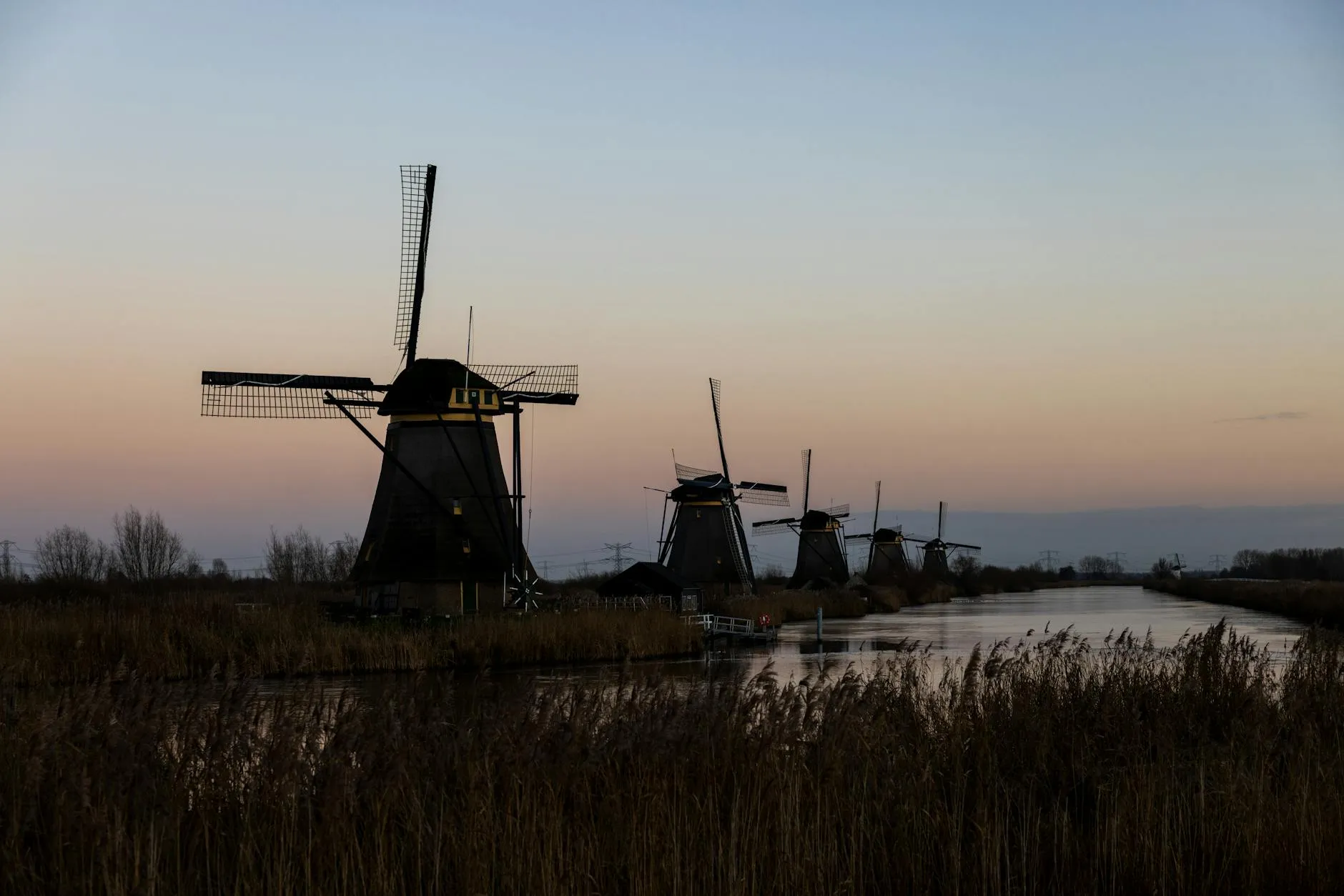 Windmills at Kinderdijk reflected in calm water at sunset