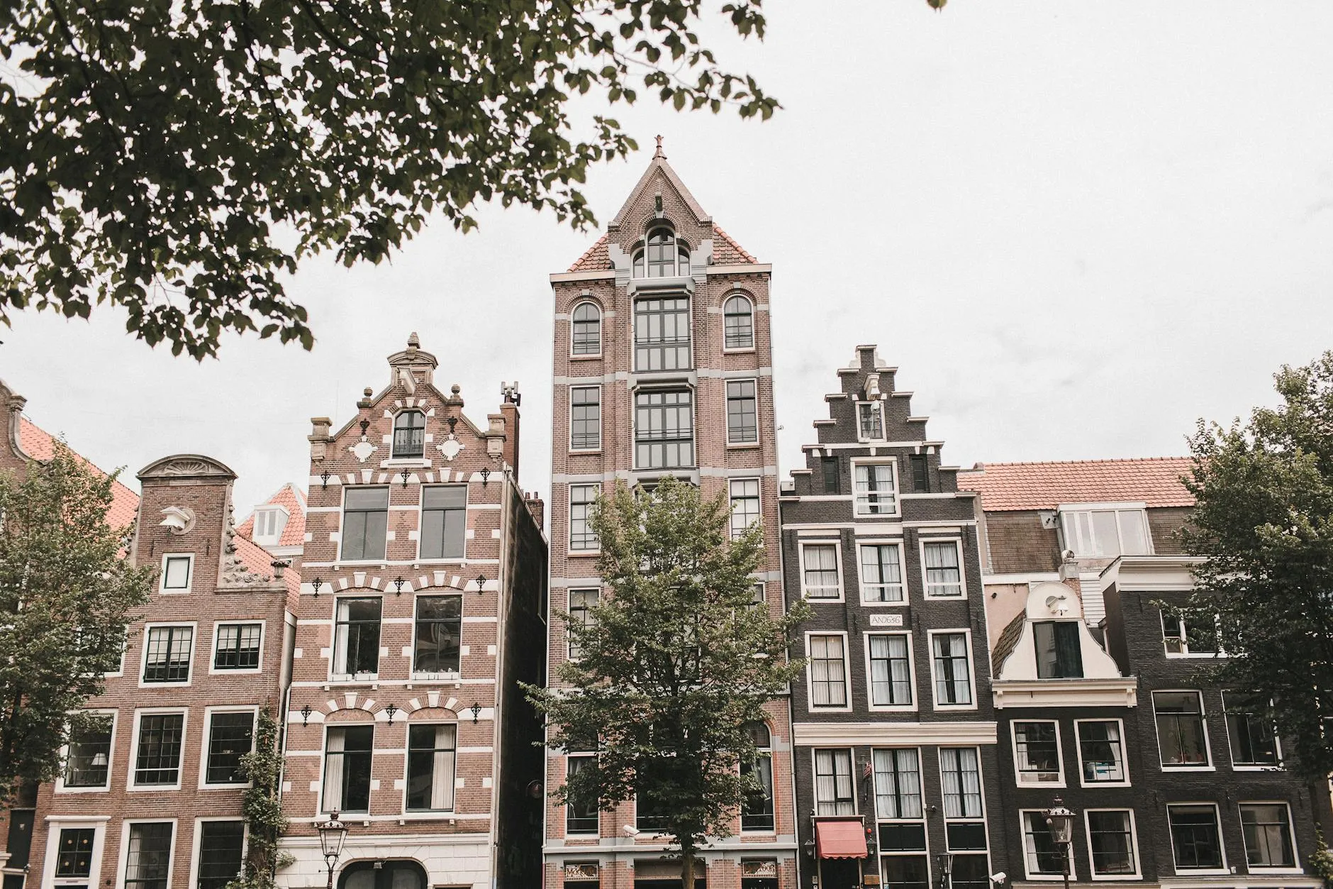 Narrow Amsterdam canal house facades with ornate gables