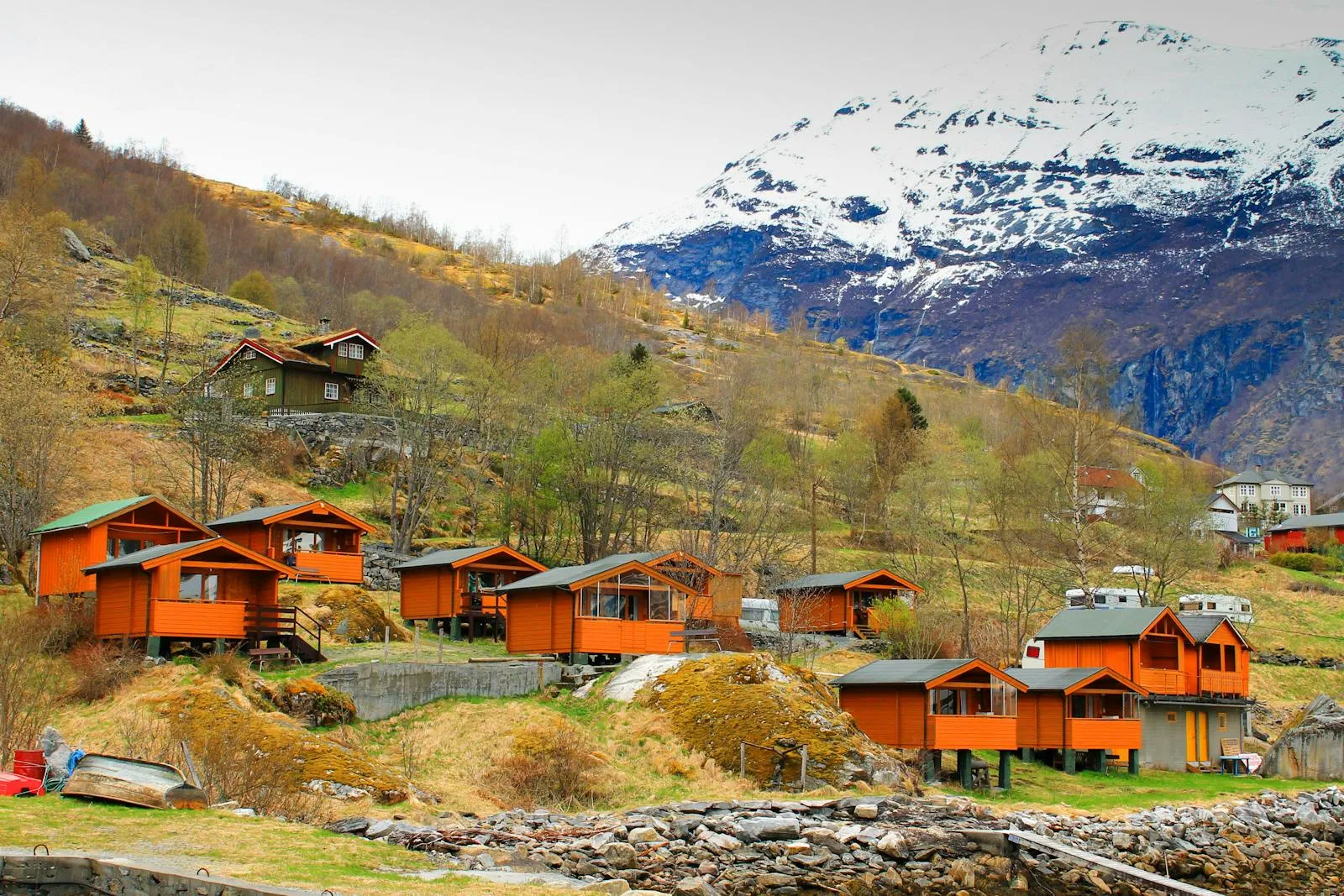 Traditional red wooden cabin by a fjord in Norway