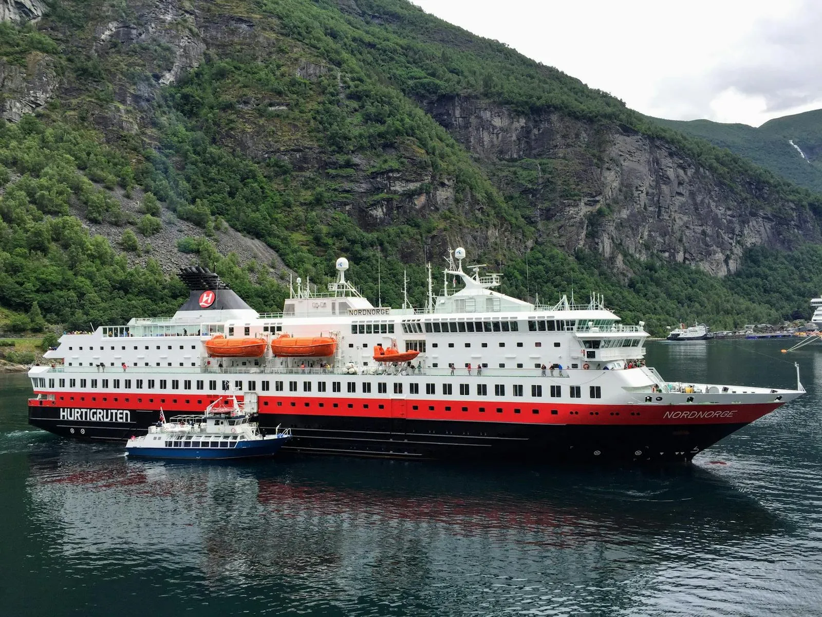 Hurtigruten coastal steamer sailing along Norwegian coast with mountains