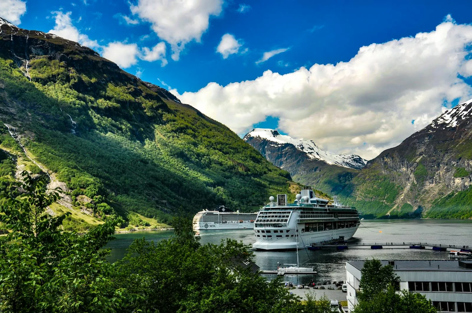 Geirangerfjord with cruise ship dwarfed by steep green mountains