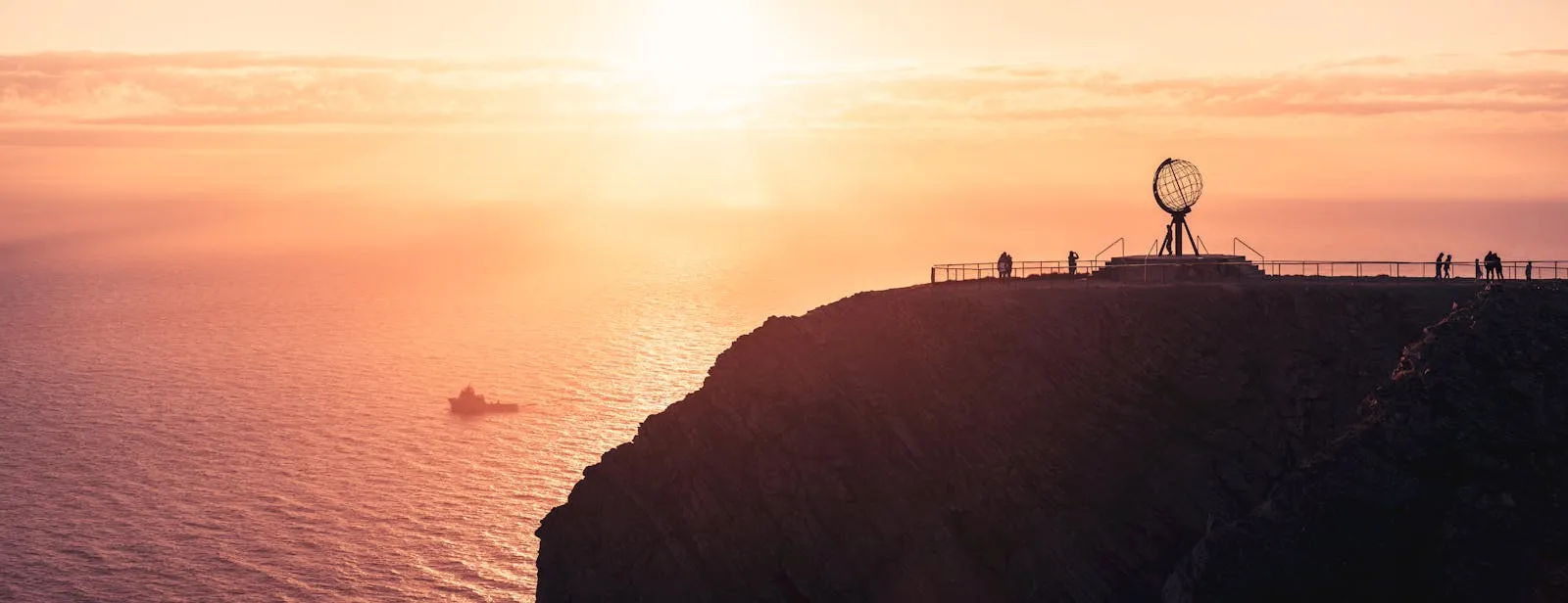 Nordkapp globe monument on cliff edge at midnight sun