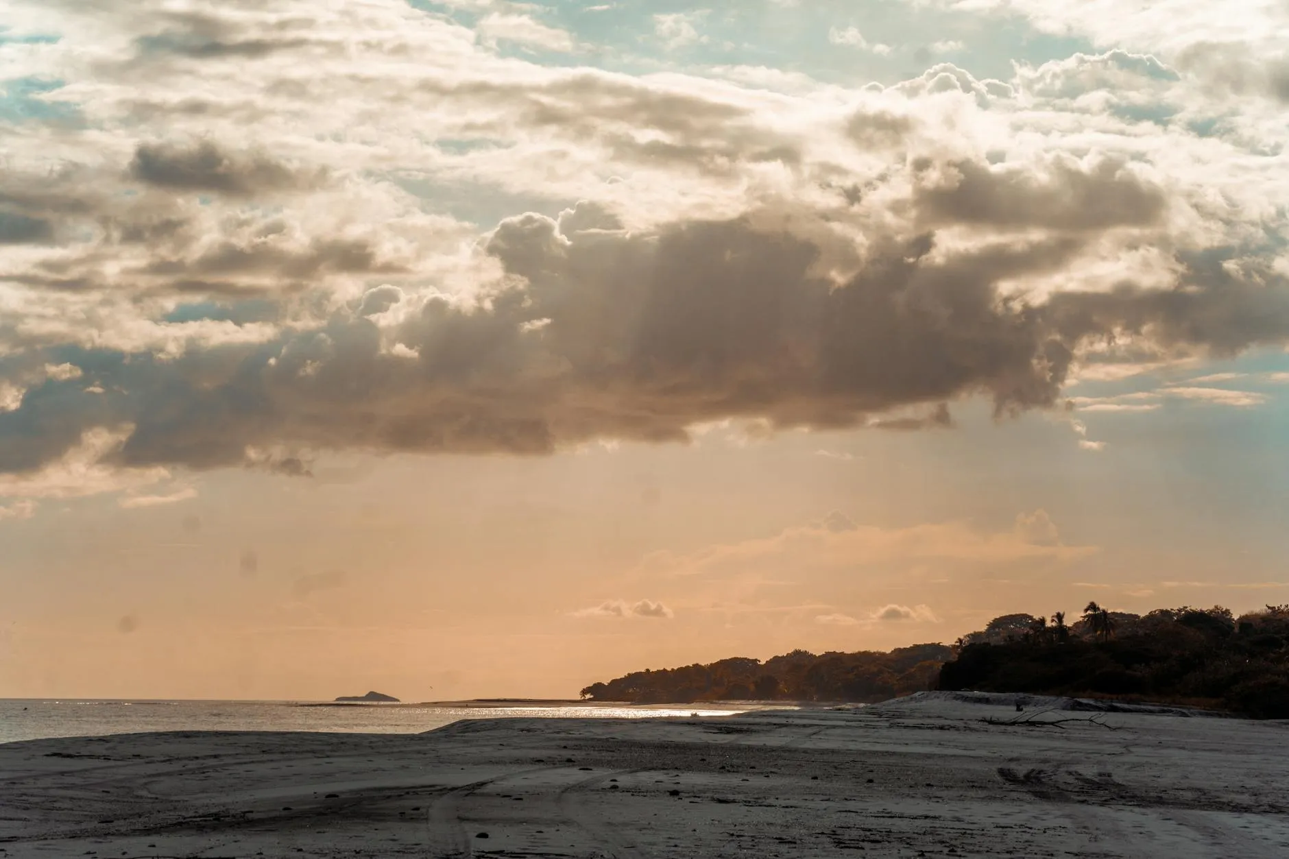 A breathtaking beach scene in Panama, showcasing a serene sunset with dramatic clouds.