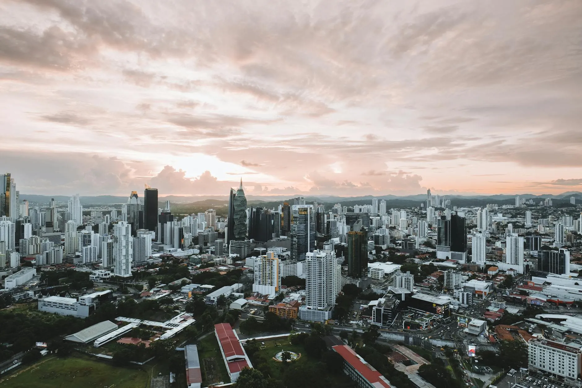 Dramatic aerial view of Panama City skyline during sunset showcasing modern skyscrapers.