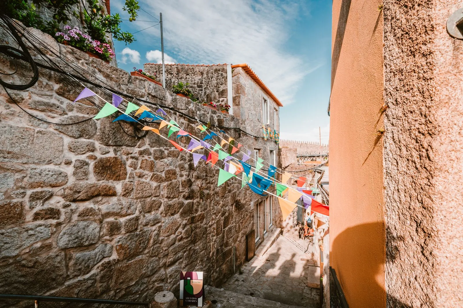 Colourful bunting strung across a stone alley during a Portuguese festival