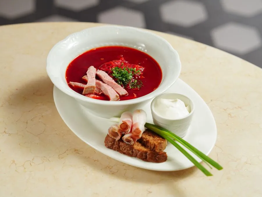 Bowl of deep red borscht with smetana sour cream and fresh dill