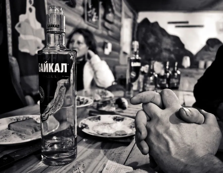 Russian vodka in small glasses with pickles and black bread on the side