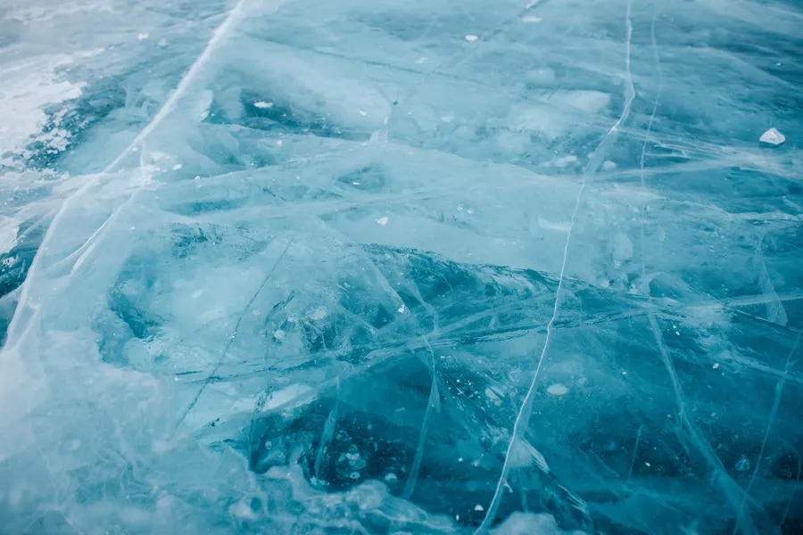 Lake Baikal frozen turquoise ice with dramatic cracks and bubbles